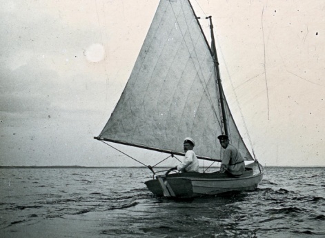 Мужчины на лодке с парусом